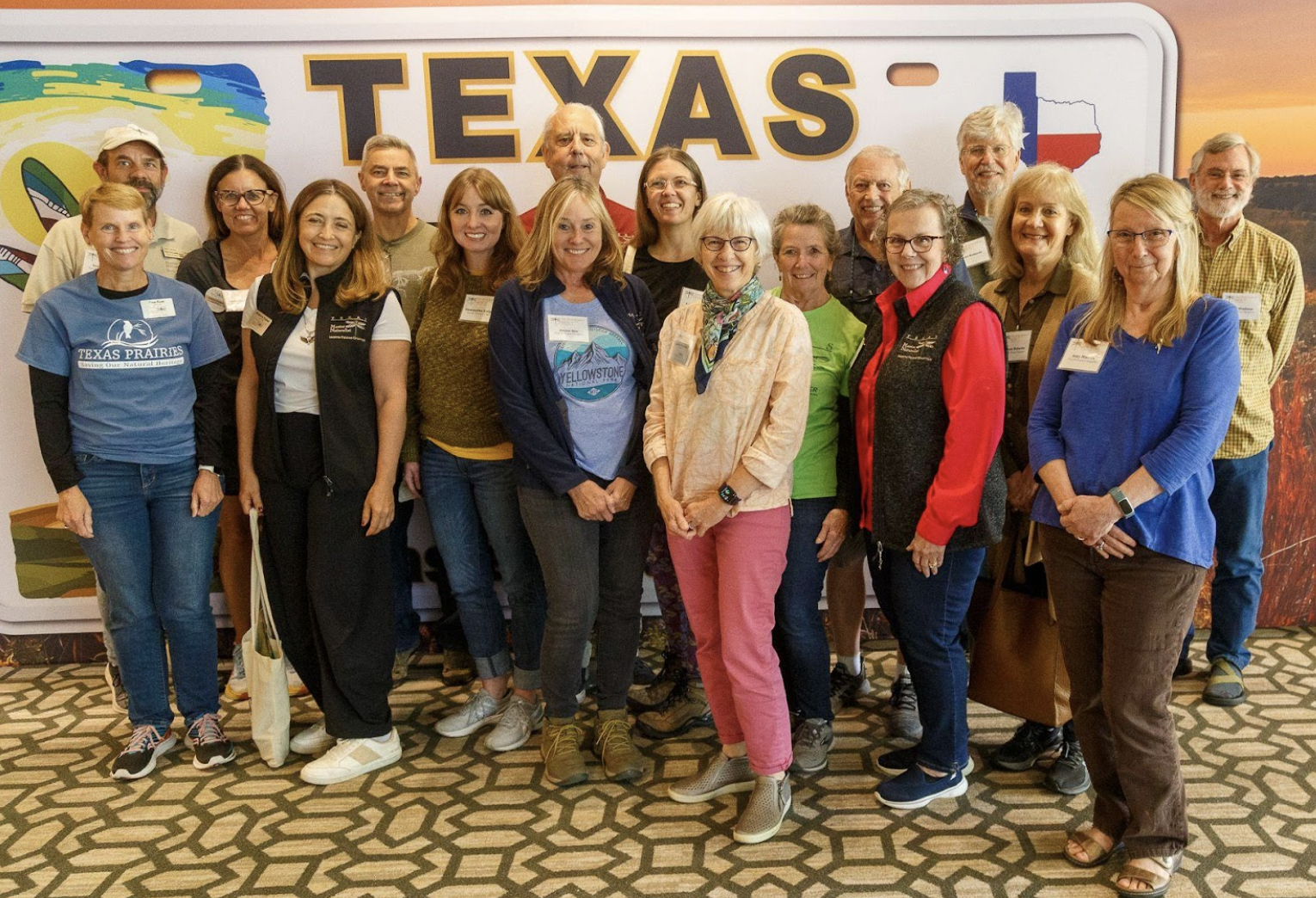 members of the chapter pose in front of a giant Texas license plate at the Annual Conference